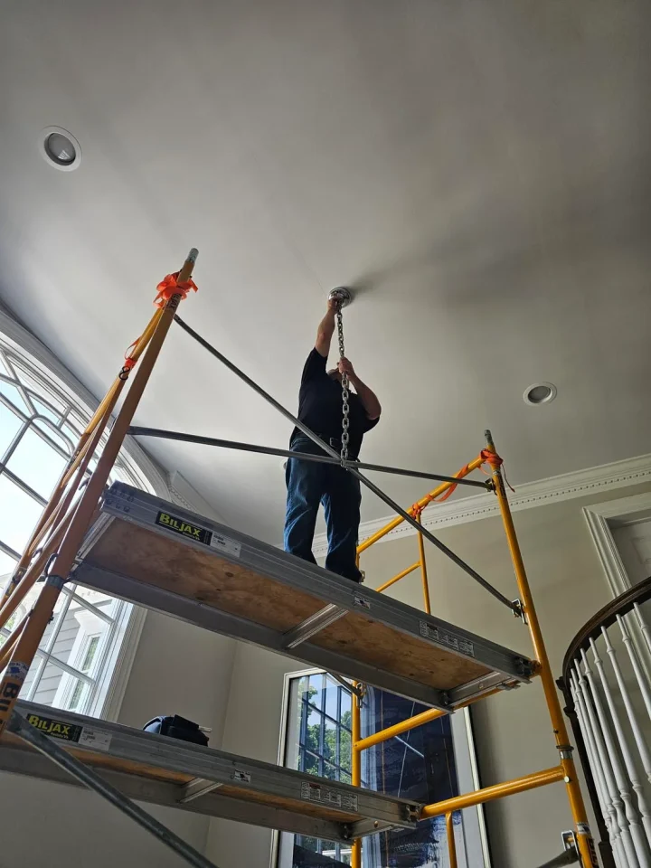 londono brothers working on chandelier chain